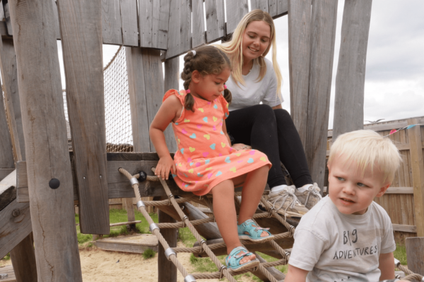 Early Years Teacher playing with children outside